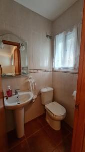 a bathroom with a white toilet and a sink at Vaca House in El Puerto de Santa María +4 photos