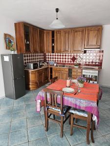 een keuken met een tafel met stoelen en een koelkast bij Casa Li Conchi in Arzachena