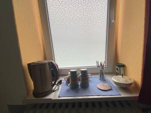 een raam met twee koffiemokken op een vensterbank bij small accomondation with possibility for wellness in Beverungen