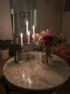 a table with candles and flowers and wine glasses at Appartment. Quiet&Nice downtown in Oslo