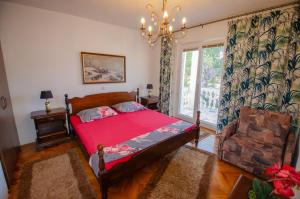 a bedroom with a bed and a chandelier at Villa Danijela with heated pool,jacuzzi and sauna in Seget Vranjica +118 photos