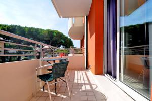 a balcony with a table and a chair on it at Hotel Cleofe in Caorle