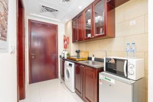 a small kitchen with a sink and a dishwasher at Budget Friendly & Studio & Golf View in Ras al Khaimah