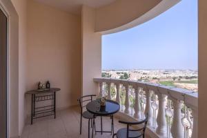 a balcony with a table and chairs and a large window at Budget Friendly & Studio & Golf View in Ras al Khaimah