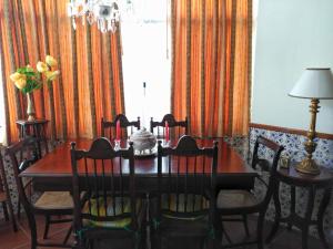 a dining room with a wooden table and chairs at Apartamento no coração da aldeia in Atouguia da Baleia +25 photos