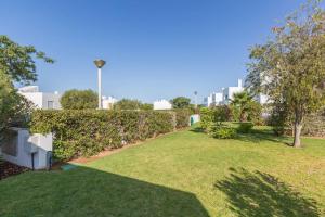 ポルシェスにあるCrastos pool & beach houseの木々や建物が並ぶ草の庭