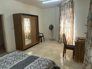 - une chambre avec un lit, une chaise et une armoire dans l'établissement Sami Apartments, à Amman
