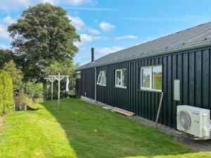 un edificio negro con un patio al lado en 6 person holiday home in Hadsund, en Haslevgårde