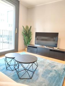 a living room with a table and a large tv at Design Apartment Vienna City Center - free parking! in Vienna