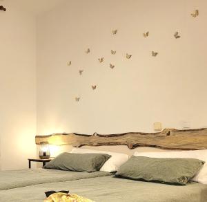 1 dormitorio con 2 camas con mariposas en la pared en HOSTEL Villanueva, 