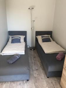 two beds sitting next to each other in a room at Przytulne mieszkanie przy parku Modrzewie in Elblag