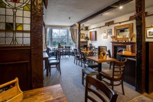 a restaurant with tables and chairs and a bar at The Wheatsheaf Inn in Carperby