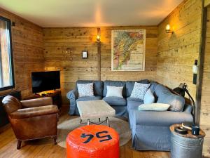 sala de estar con sofá azul y TV en Chalet Vieux Bois, au coeur du village des Rousses, en Les Rousses