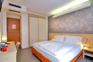 a bedroom with a bed and a desk and a bed sidx sidx sidx at Eco Hotel Cleofe in Caorle