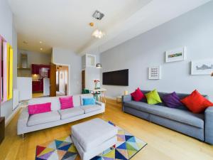 a living room with two couches and a tv at Fitzrovia Mansion Apartments in Belfast's Cathedral Quarter in Belfast