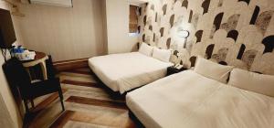 una camera d'albergo con due letti e una parete di 慶爾喜旅館Goodscompany a Taipei