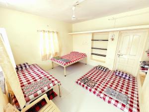 a room with two beds in a room at Shriguru Guest House Akkalkot in Akalkot