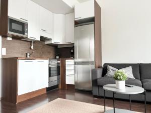 a kitchen with a couch and a table in a room at Tammer Huoneistot - City Suite 2 - City View & Perfect location in Tampere