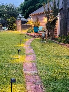 a brick path in a yard with a table and chairs at The Coziest Cottage in Waxahachie in Waxahachie