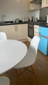 a kitchen with a white table and white chairs at Bexhill Sea View Flat 3 in Bexhill