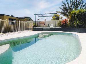 ein Pool in einem Garten mit einem Zaun in der Unterkunft Sunny Shores House with Private Pool in Lake Illawarra