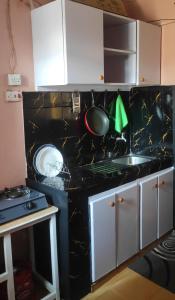 een keuken met een zwart aanrecht en een wastafel bij Elegantly furnished 1bedroom at Claycity, Thika Rd in Nairobi