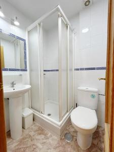een badkamer met een douche, een toilet en een wastafel bij Pensión el Carmen in Alcobendas