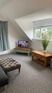 a living room with a couch and a tv at Bexhill Sea View Flat 3 in Bexhill