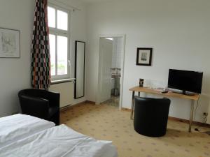 a bedroom with a bed and a desk with a computer at Pension Villa am Burgberg in Waltershausen