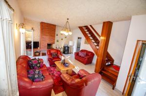 a living room with red leather furniture and a staircase at Villa Danijela with heated pool,jacuzzi and sauna in Seget Vranjica