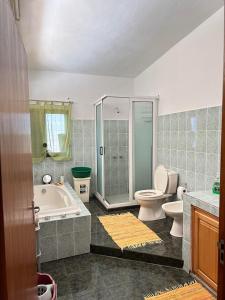 uma casa de banho com uma banheira, um WC e um chuveiro em Bella Vista Holiday Home em Triolet