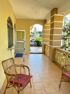 a room with two chairs and a table and a porch at Bella Vista Holiday Home in Triolet
