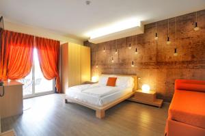 a bedroom with a bed and an orange couch at Eco Hotel Cleofe in Caorle