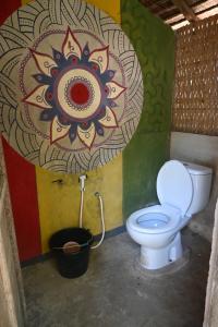 a bathroom with a toilet and a painting on the wall at Bunga Jabe in Karimunjawa