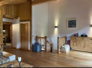 een woonkamer met houten vloeren en houten meubilair bij Le Chalet du Crêt - 8 pers, tout confort avec Jacuzzi in Notre-Dame-de-Bellecombe