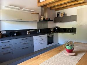 een grote keuken met witte kasten en een tafel bij Le Chalet du Crêt - 8 pers, tout confort avec Jacuzzi in Notre-Dame-de-Bellecombe +7 foto's