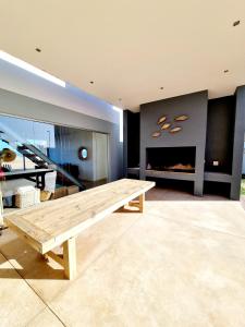 una mesa de madera en una sala de estar con chimenea en Henties Bay Haven Holiday Home, en Henties Bay