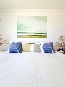 a bedroom with a white bed with blue pillows at Henties Bay Haven Holiday Home in Hentiesbaai