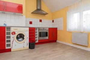 cocina con armarios rojos y lavadora en Gîte en centre historique 65m2, en Beaugency