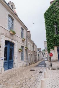 una calle adoquinada con una puerta azul en un edificio en Gîte en centre historique 65m2, en Beaugency