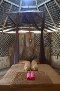 two pink slippers sitting on a bed in a tent at Bunga Jabe in Karimunjawa