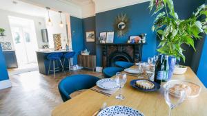 a dining room with a table and blue walls at Claremont in Llanfairfechan