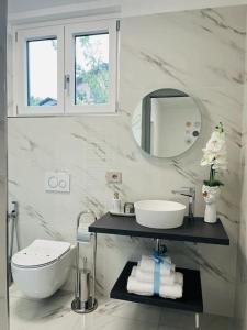 a white bathroom with a sink and a mirror at Casa El Trigal in Colico