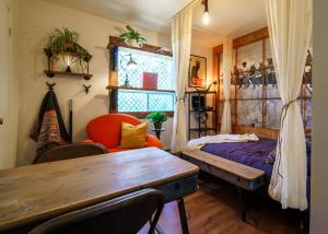 um quarto com uma mesa, uma cama e uma janela em Le Refuge du Repaire em Saint-Alexis-des-Monts