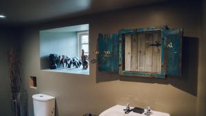 a bathroom with a sink and a window and a toilet at Bodfan Bach in Llandwrog