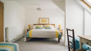 a bedroom with a bed with colorful pillows at Bodfan Bach in Llandwrog