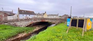 un ponte di pietra sopra un fiume in una città di West View Cottage in Seaside Village of Allonby Cumbria ad Allonby Altre 14 foto