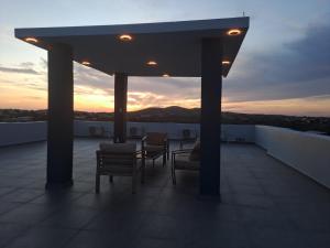 Un balcón con sillas y una puesta de sol al fondo. en CG Apartment - Kibrahacha, en Willemstad