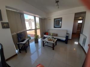 een woonkamer met een bank en een tafel bij Reflejo de Mar in Villa Gesell