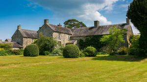 an old stone house with a large yard at Ty Fry Manor in Pentraeth